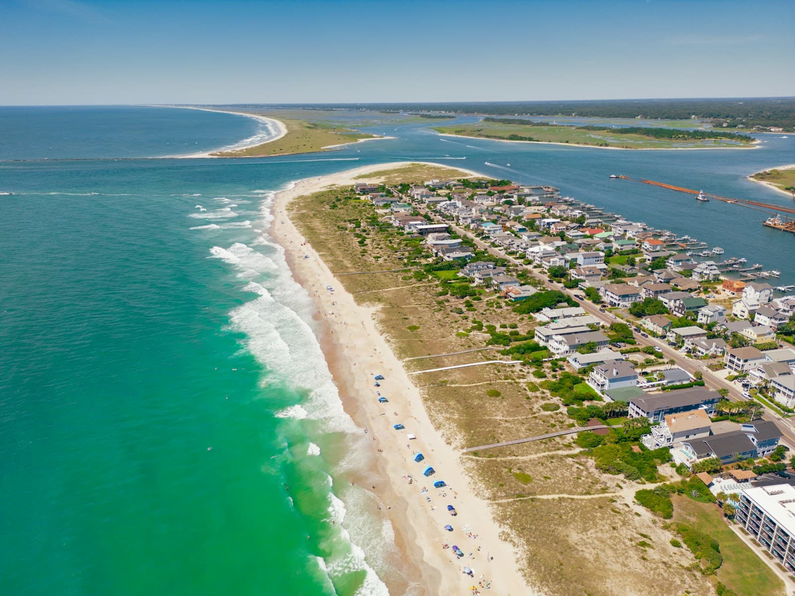 Aerial view of beachfront residential community with white sand beach and turquoise ocean waters