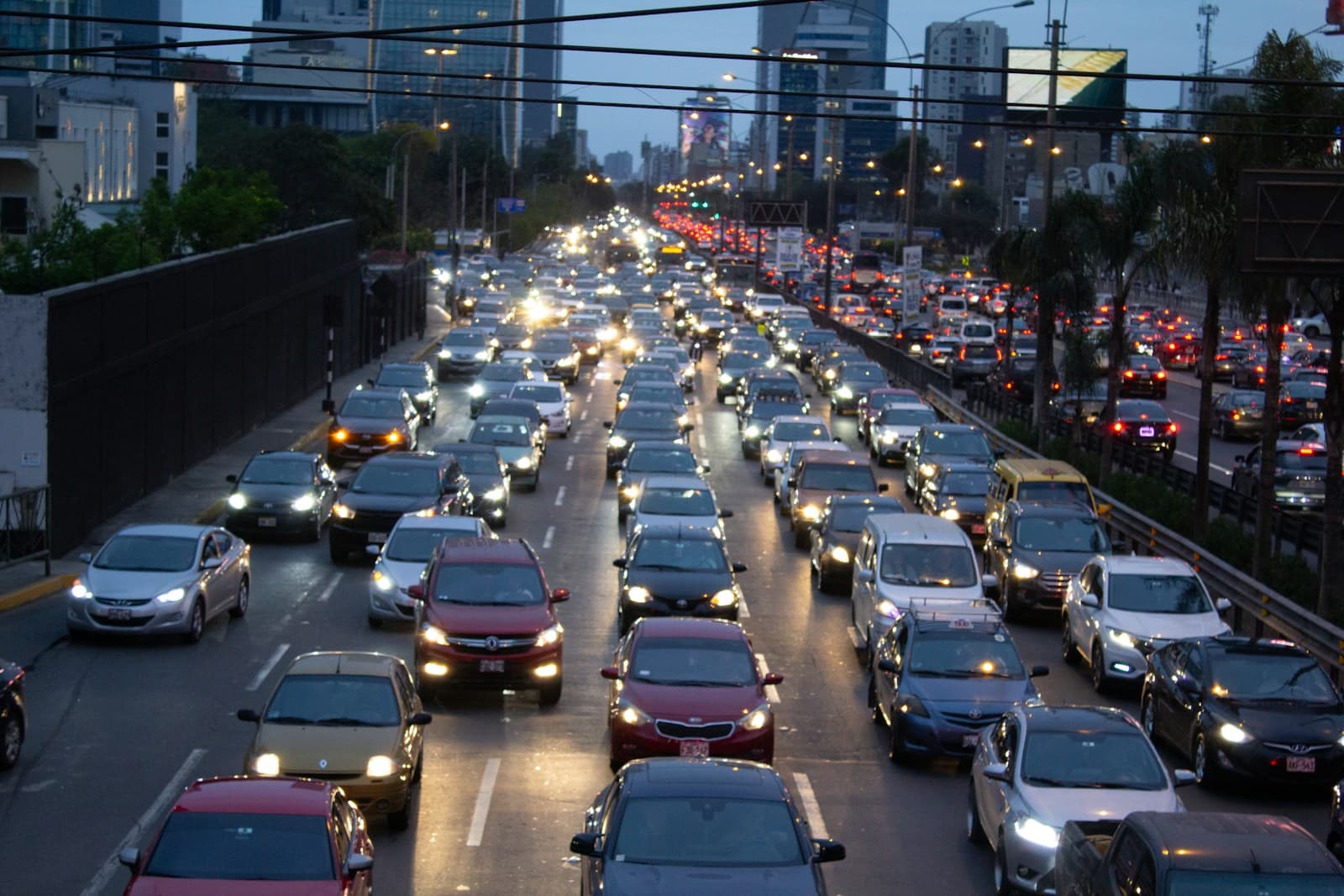 Heavy traffic congestion on multi-lane highway during evening rush hour with cars and headlights visible