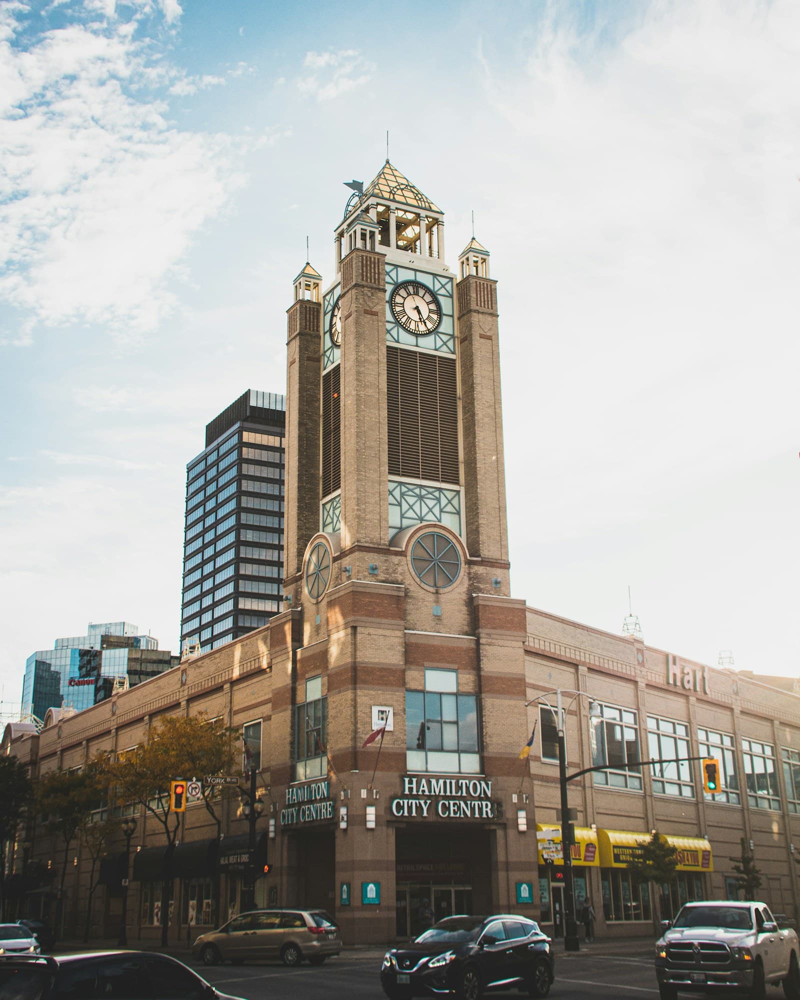 Historic brick clock tower of Hamilton City Center with modern office buildings in background